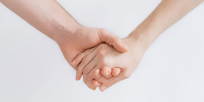Tvä händer som håller i varandra och ger stöd