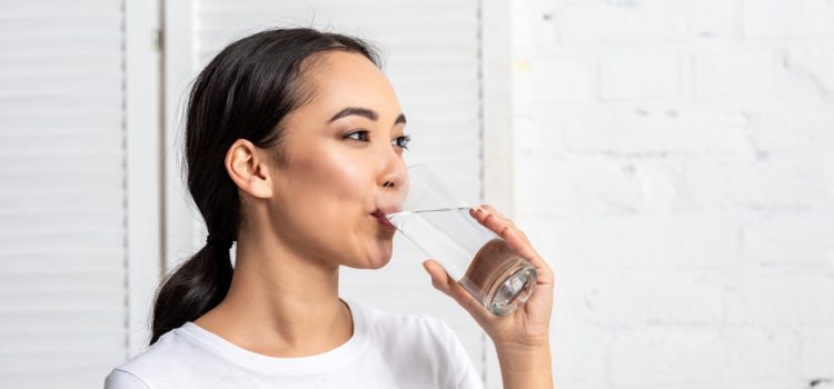 Kvinna lider av muntorrhet dricker vatten